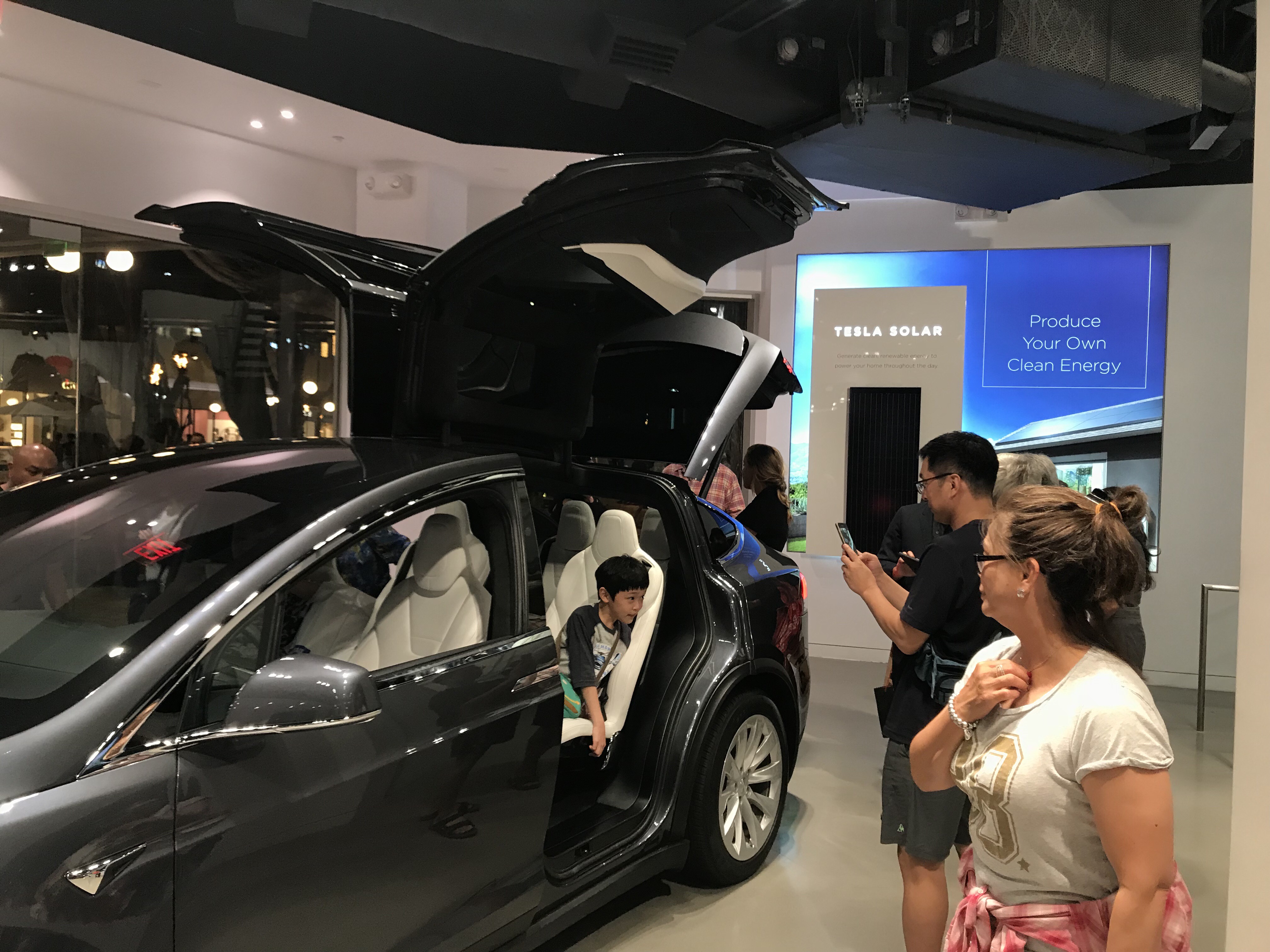 Model X on the floor with Tesla Solar energy wall behind